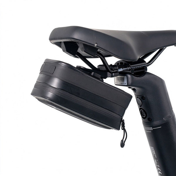 The black ADO CB11 bicycle saddle bag securely mounted under the bike seat using the AQS Mag quick-release system, offering compact storage for your ride.