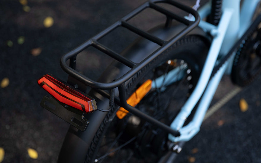 Urban e-bike rider cycling safely at night in the UK with integrated lights and reflective details