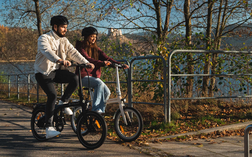 A commuter riding a folding e-bike in a UK city with greenery and eco-friendly urban surroundings.