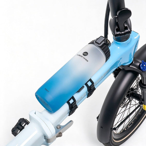 The ADO CC02 750ml bike water bottle securely mounted on a light blue bicycle frame using the AQS Mag quick-release system.